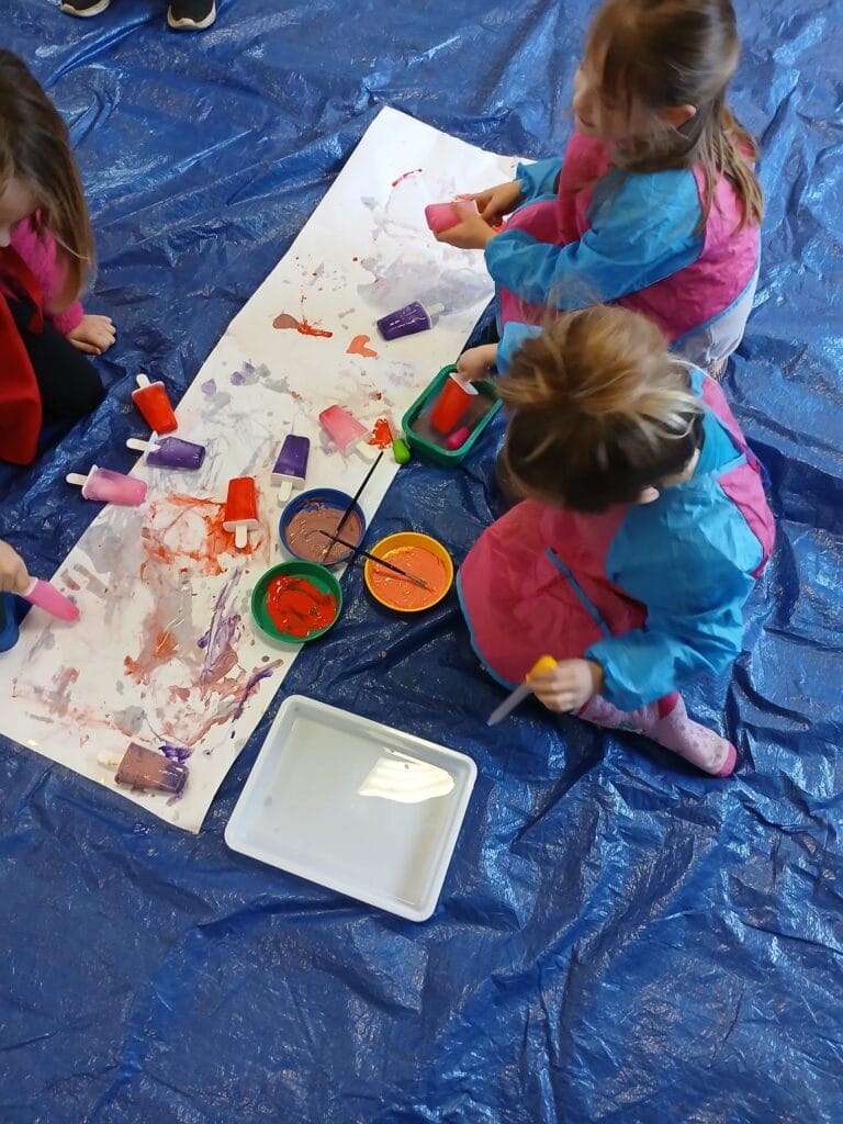 Melting ice paint cubes creating vibrant art – a fun and refreshing summer activity to keep kids cool and creative
