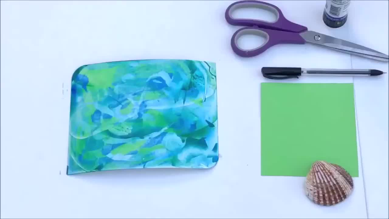 Using an old credit card to scrape paint in swirling patterns across card.