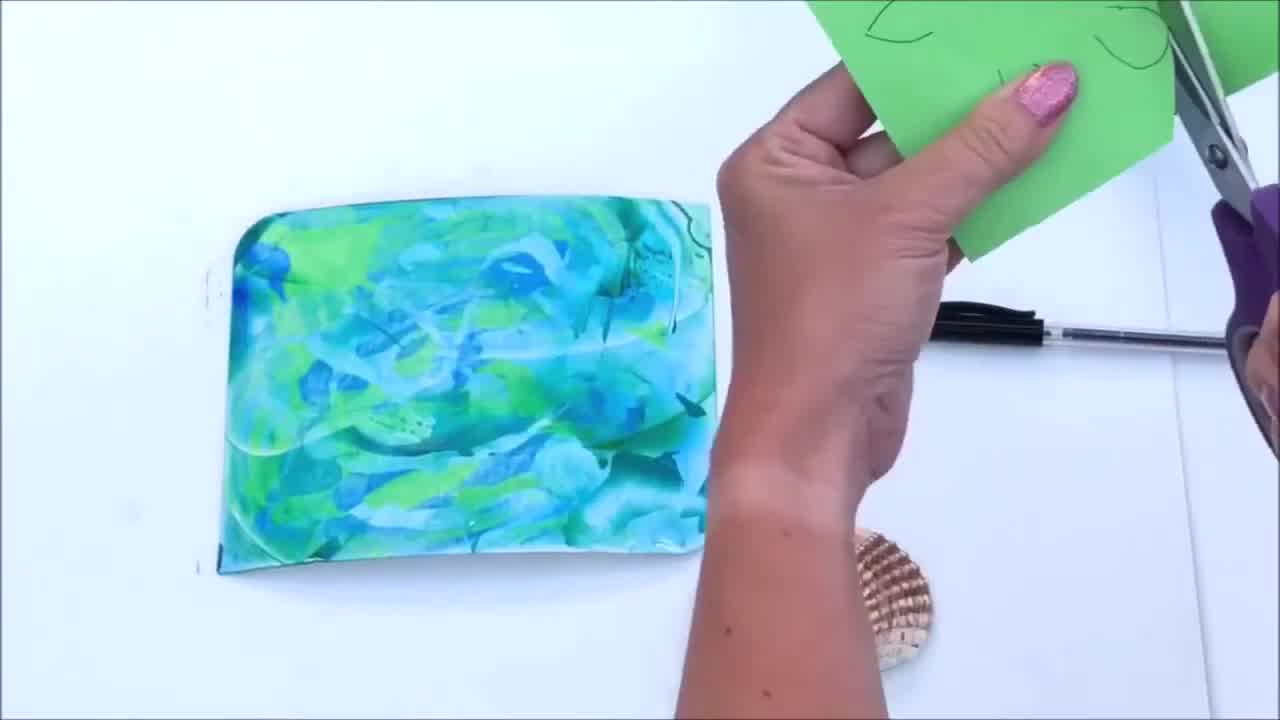 Cut-out turtle head, arms, and legs from green paper next to painted shell.