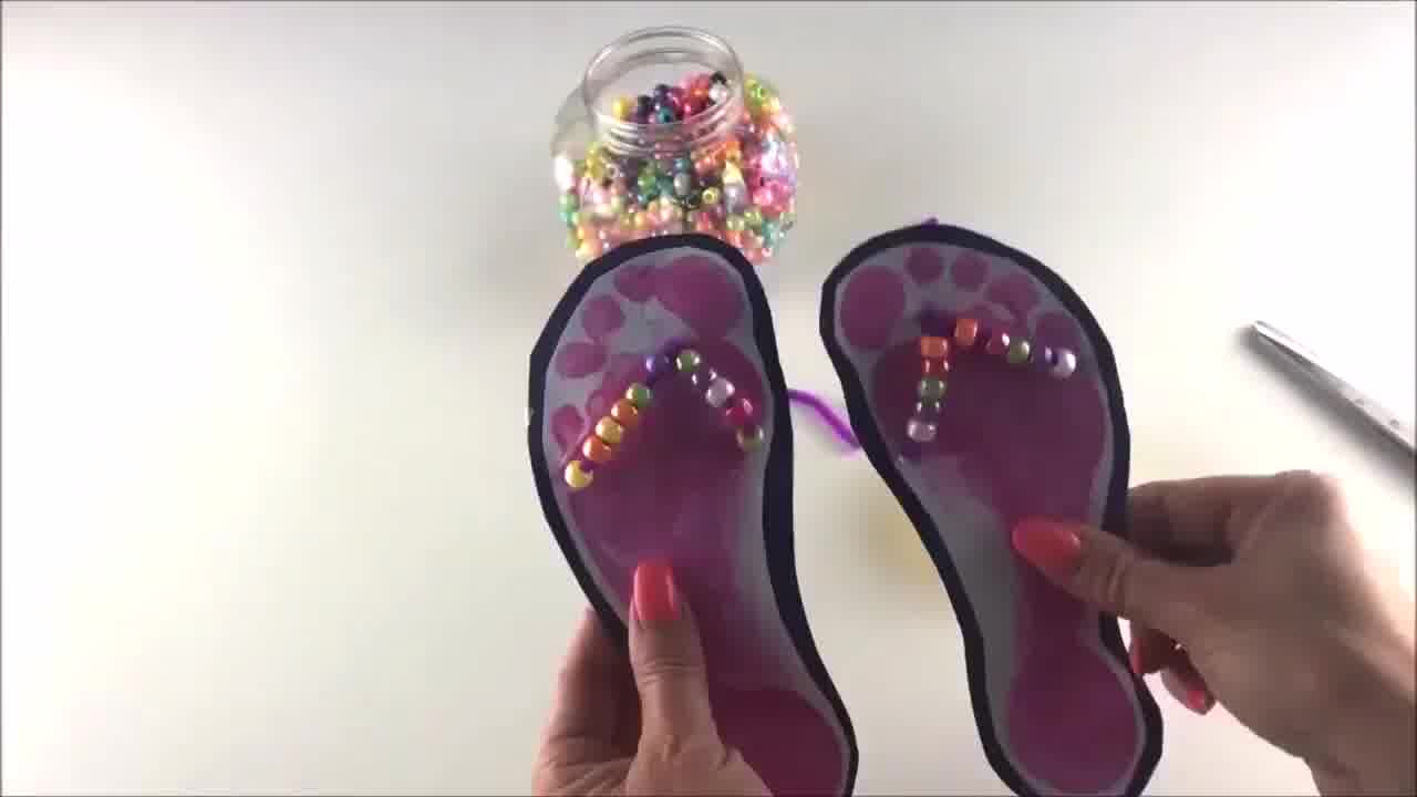Threading beads onto pipe cleaner – colourful beads being added to pipe cleaner flip flop straps.