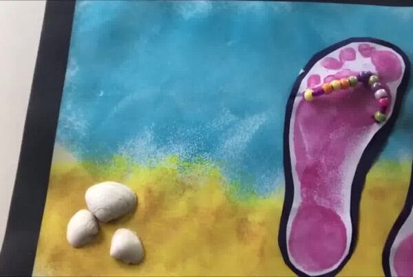 Finished beaded flip flops craft – vibrant footprint flip flops decorated with beads and displayed on a seaside-themed background.