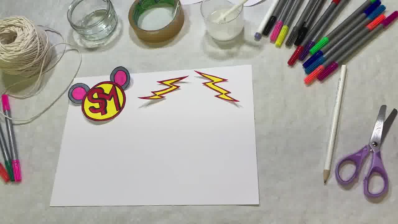 decorating a cardboard superhero mask with bright colours