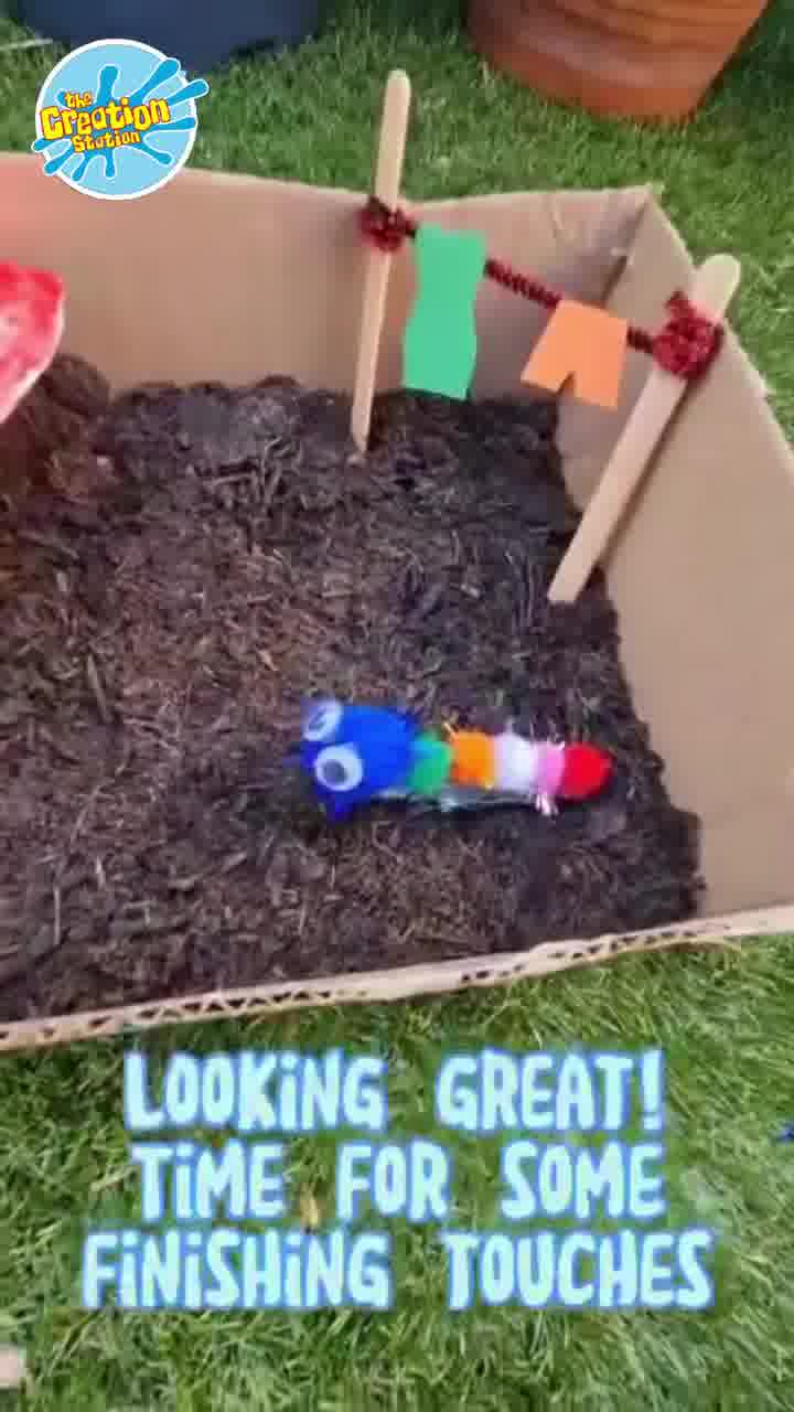 Fairy garden coming to life with mini fences, painted pebbles, and pretty flowers