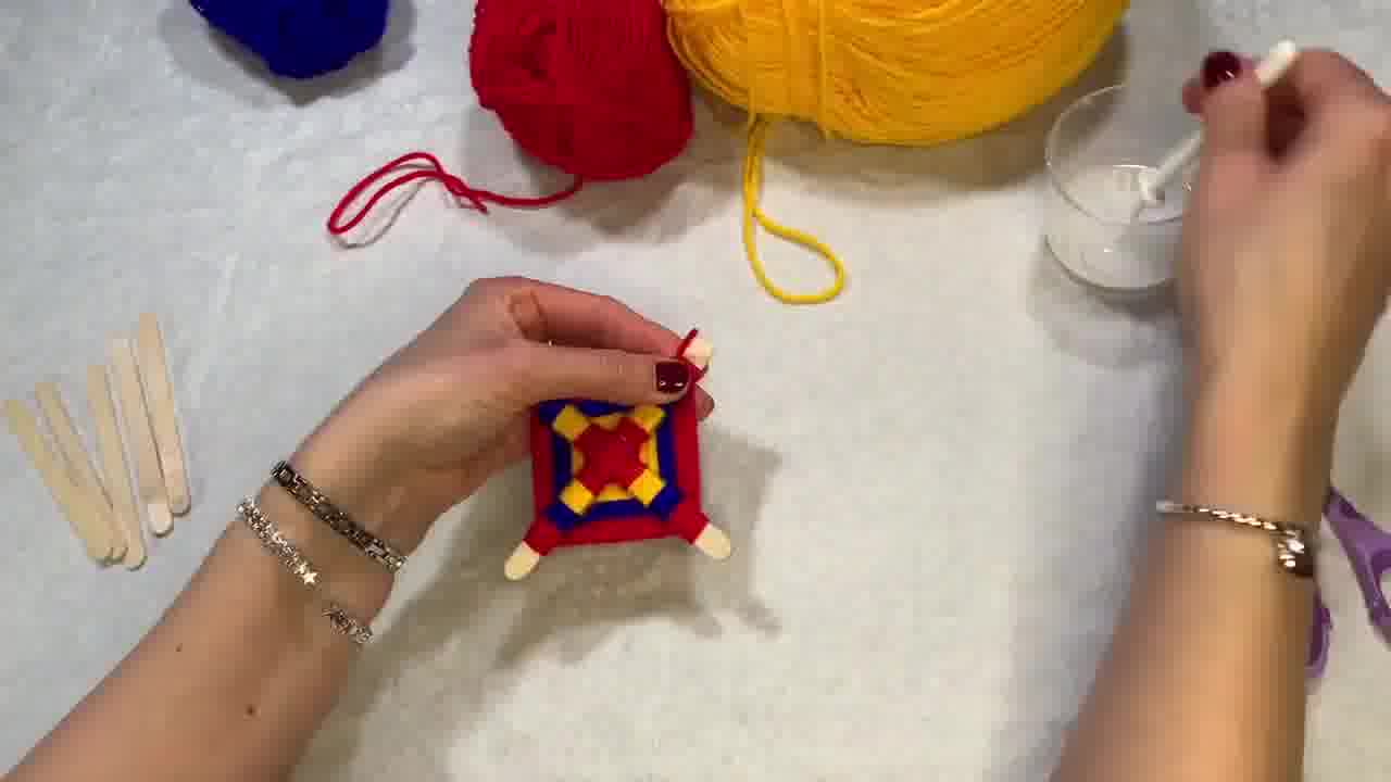 Bright layers of coloured wool building up around the sticks as the design grows.