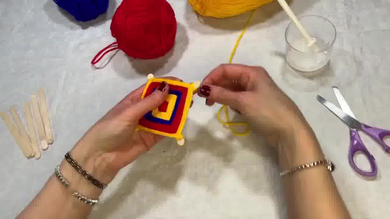 Almost complete Ojo de Dios with multiple colours and a few sections of stick still showing.