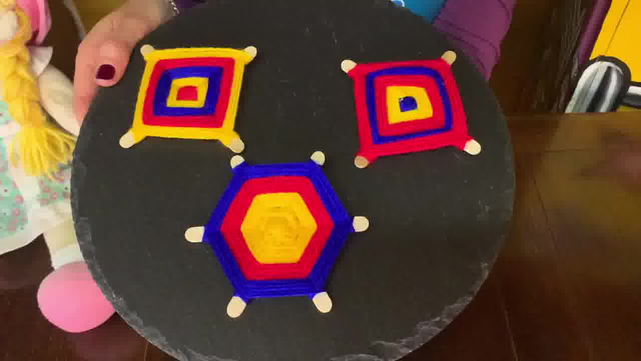 Completed Ojo de Dios with colourful woven pattern, ready to hang or display.