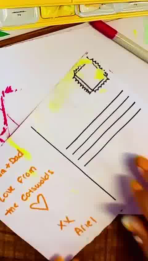 writing a cheerful message on the back of a postcard