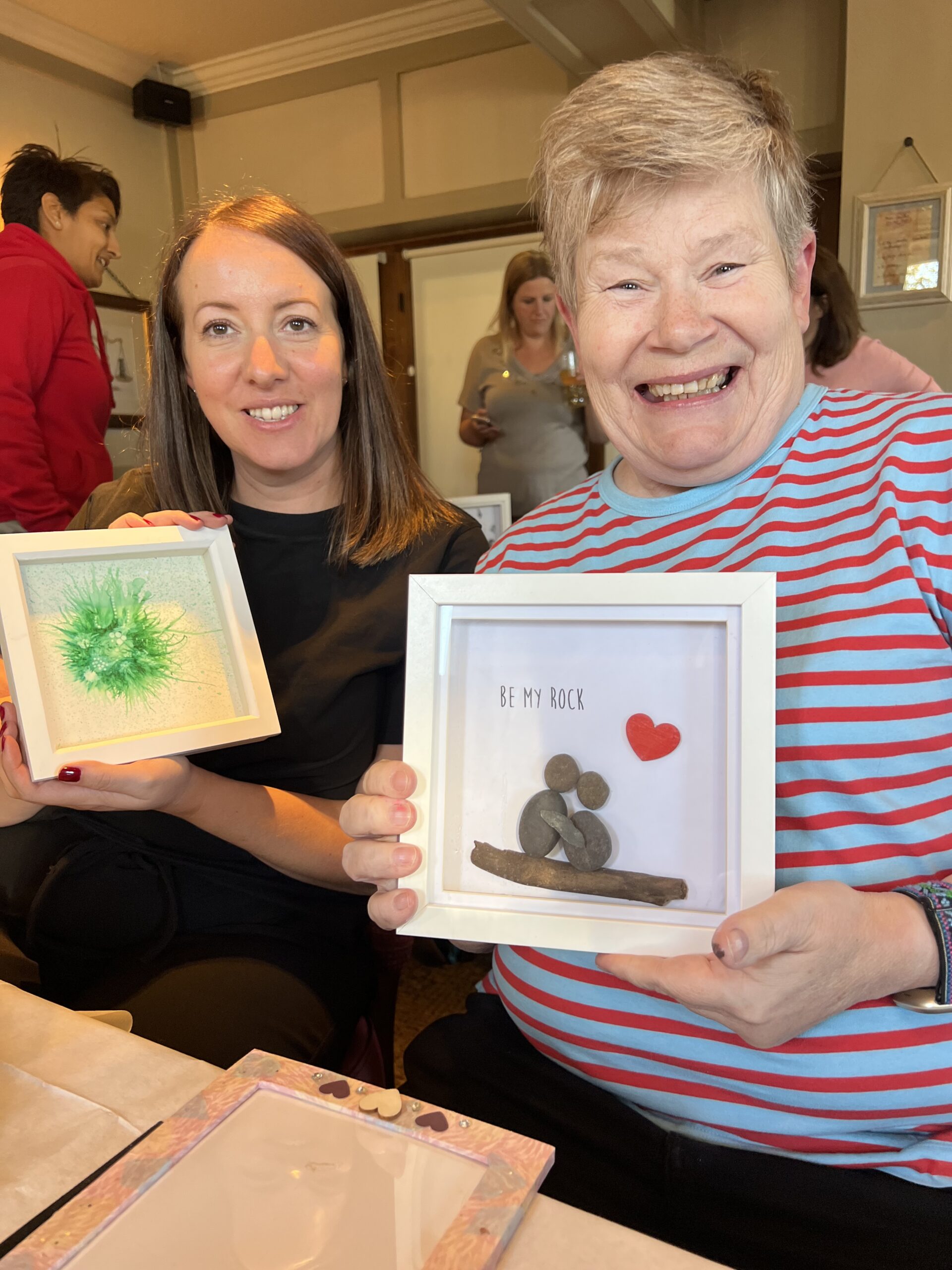 Smiling participants holding arts and crafts creations