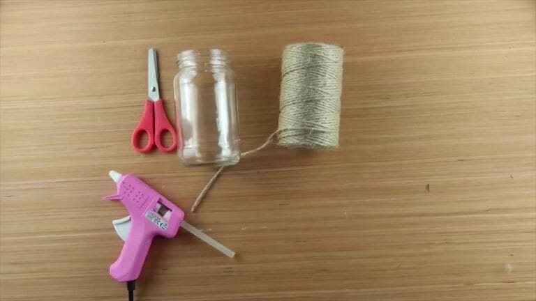 Glass jar, string or twine, glue, scissors, and optional decorations laid out on a table