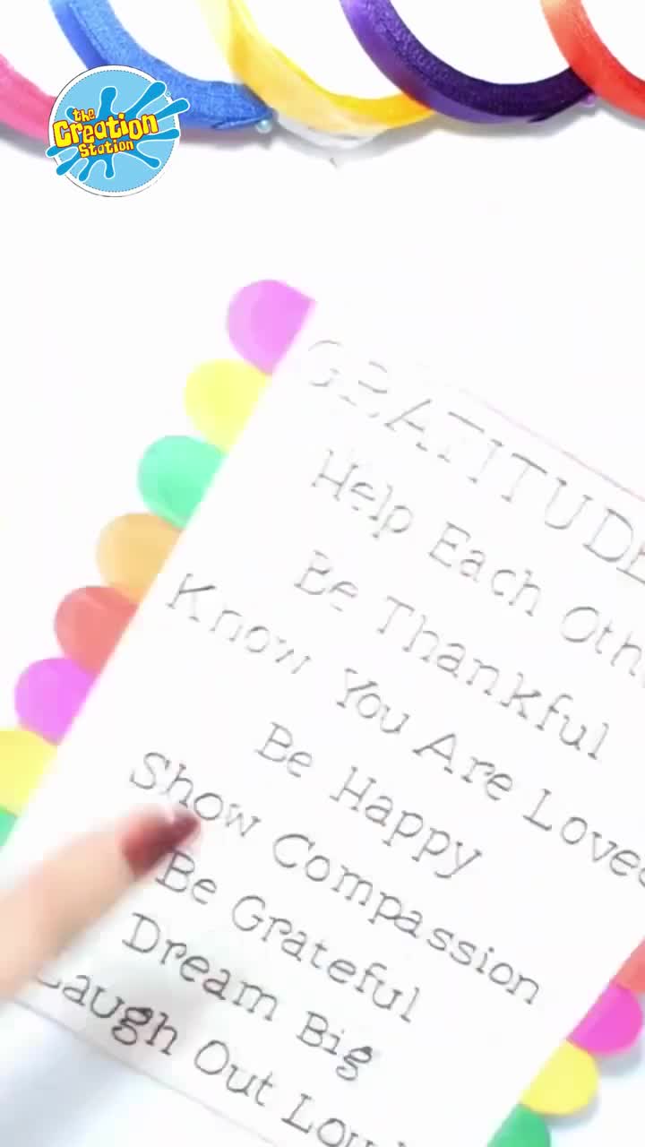 Hand writing words of gratitude on paper shapes to include in the artwork