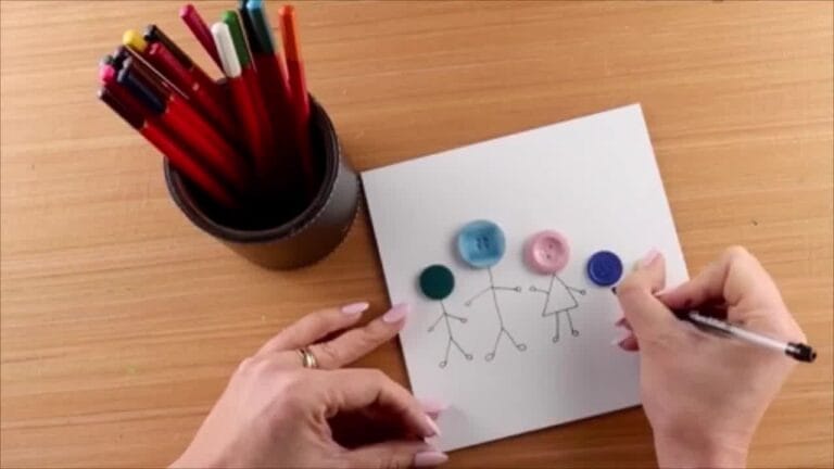 Close-up of hands adding small buttons and embellishments to complete the design