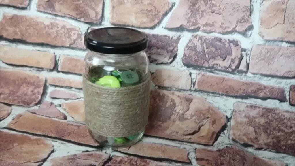 Completed jar decorated with string and embellishments, ready to be used as a vase or decorative piece
