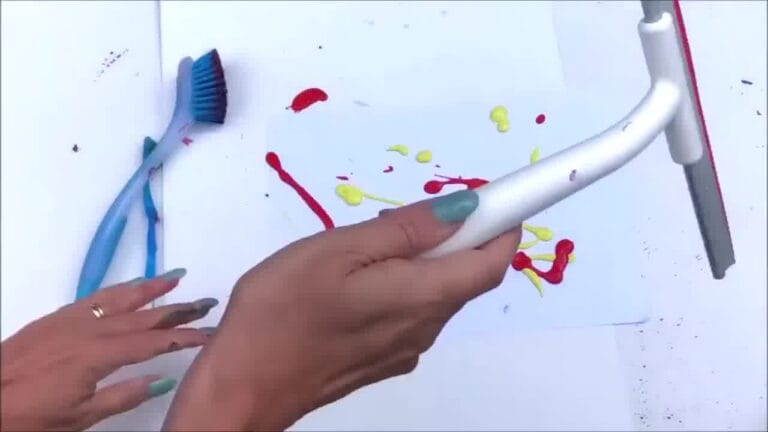 Hands experimenting with different tools like squeegees and brushes to make fun paint effects