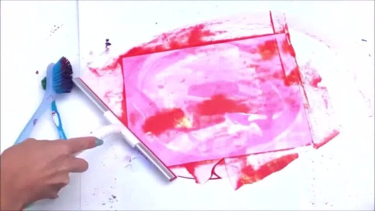 creating art using a squeegee to spread paint across paper.