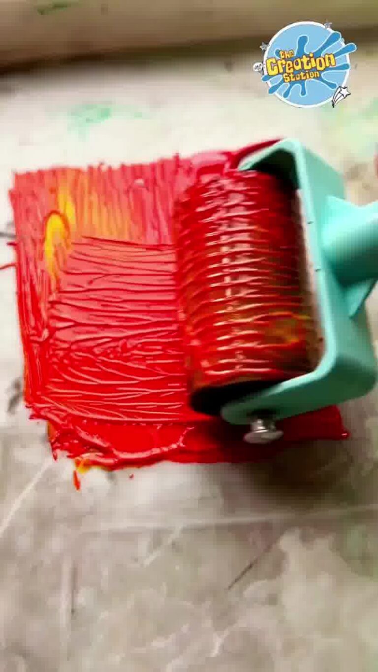 Ink being rolled evenly over the carved lino block with a brayer