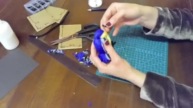 Trimming loose yarn ends and adjusting shapes to make the bird look neat and complete.