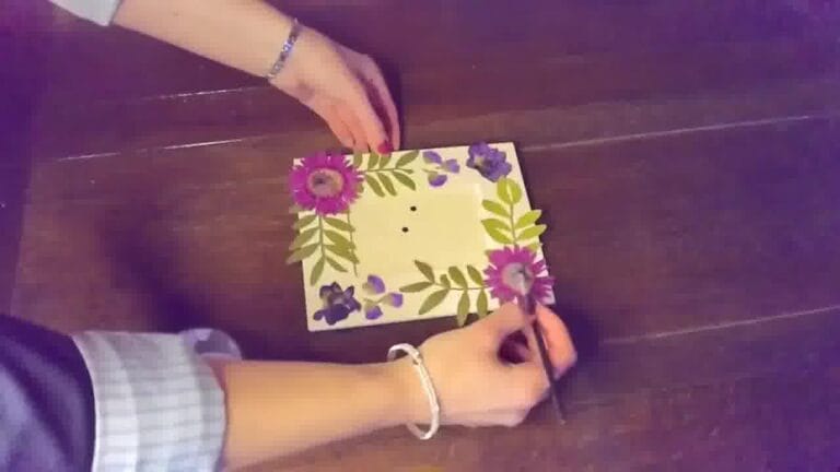 Pressed flowers arranged on the border of a photo frame, ready to be glued for decoration